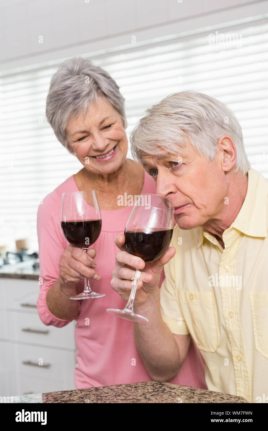 Senior couple drinking red wine at home in the kitchen Stock Photo - Alamy