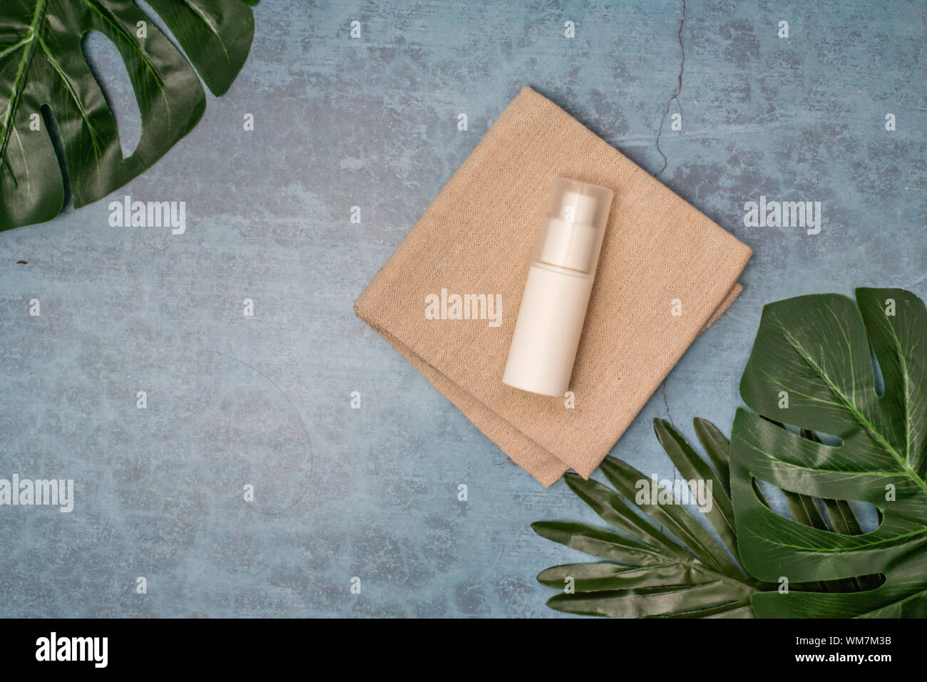 cosmetic product and tropical leaves on concert background, cosmetic product Stock Photo