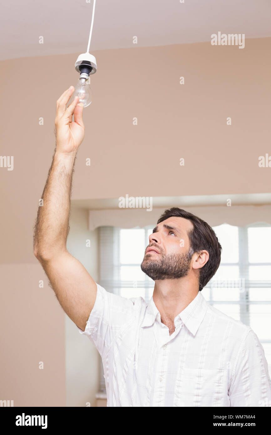 Man replacing the light bulb at home in the living room Stock Photo - Alamy
