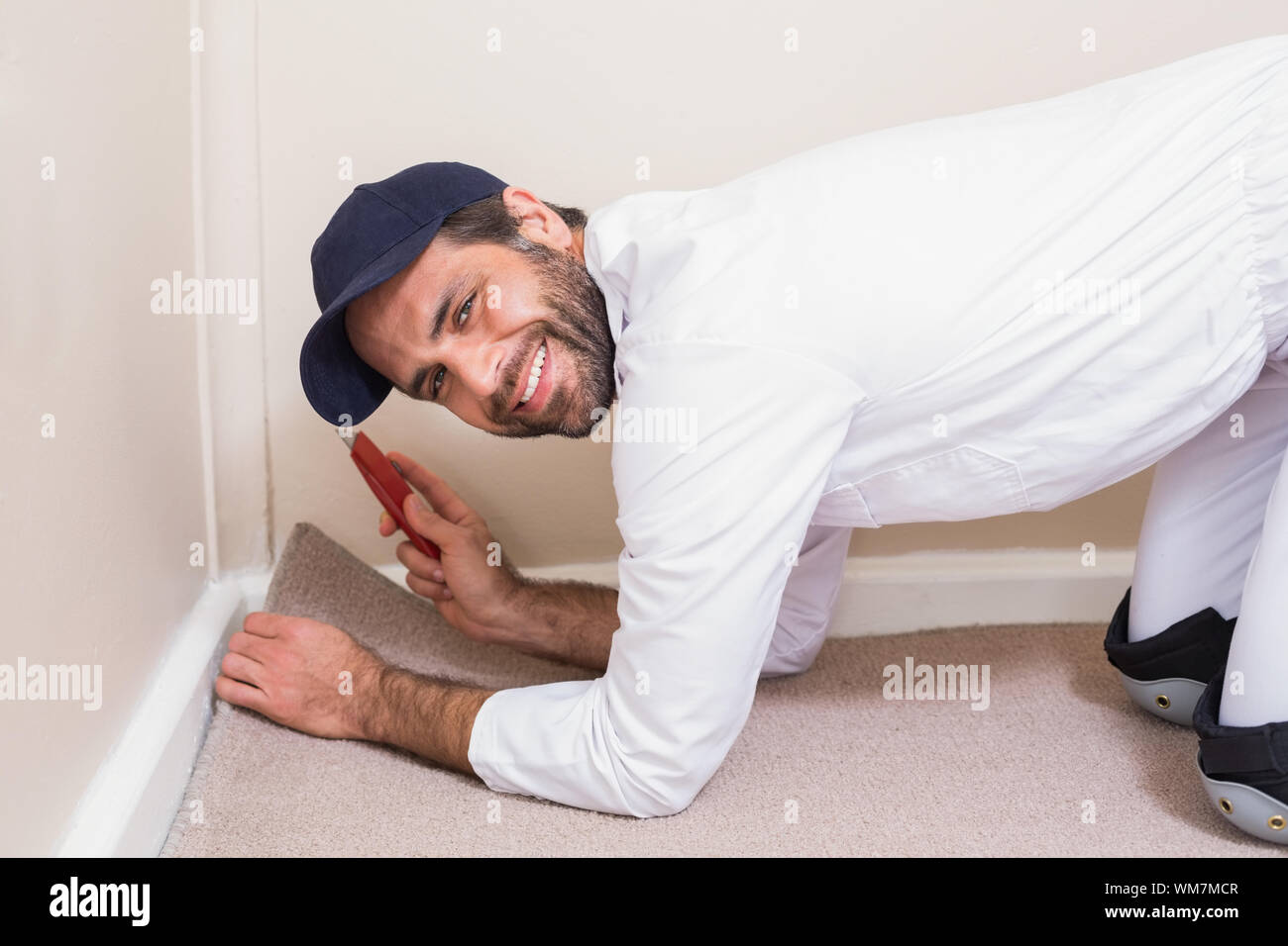 Handyman laying down a carpet in a new house Stock Photo - Alamy