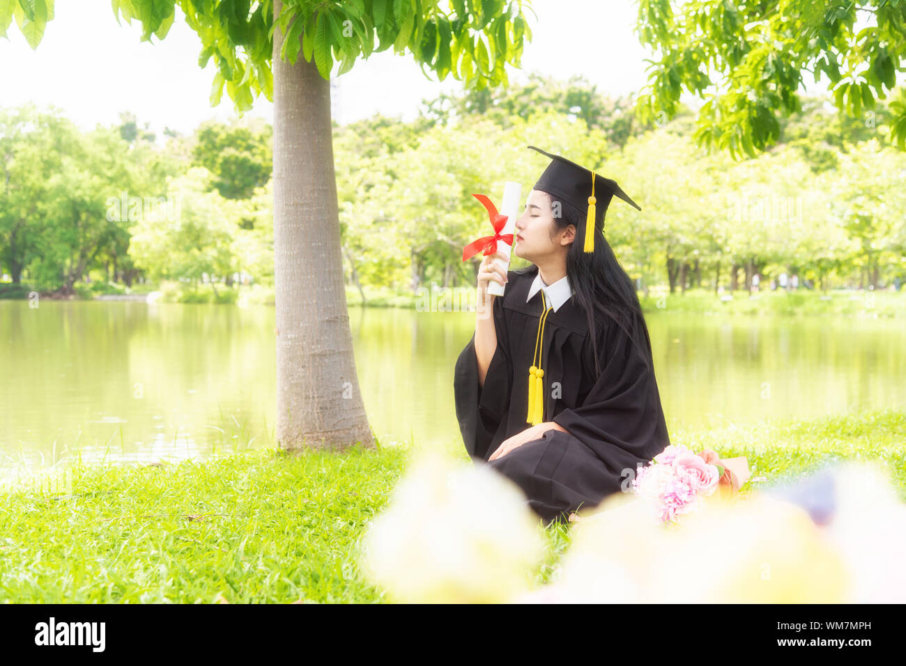 Beautiful asian women graduating holding diploma with pride and smiling ...