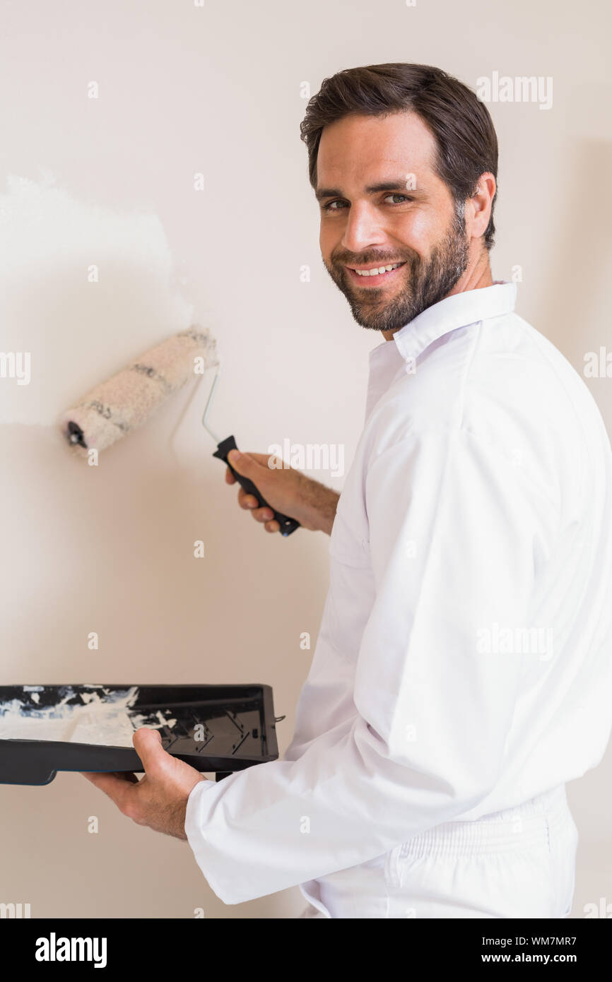 Painter painting the walls white in a new house Stock Photo Alamy