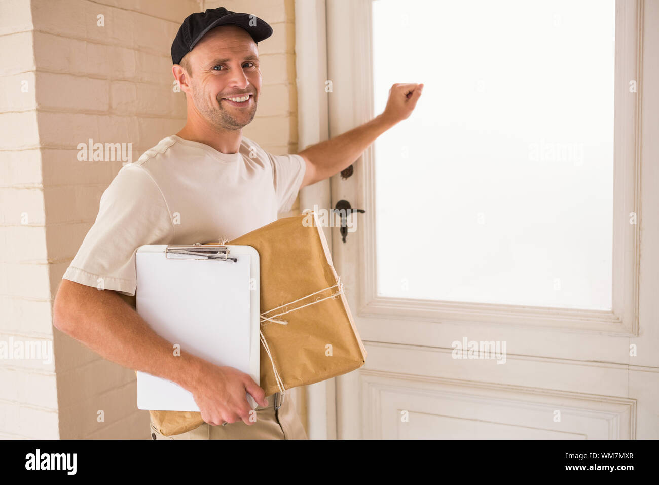 Smiling Handyman Knocking At The Door Of Someones Home Stock