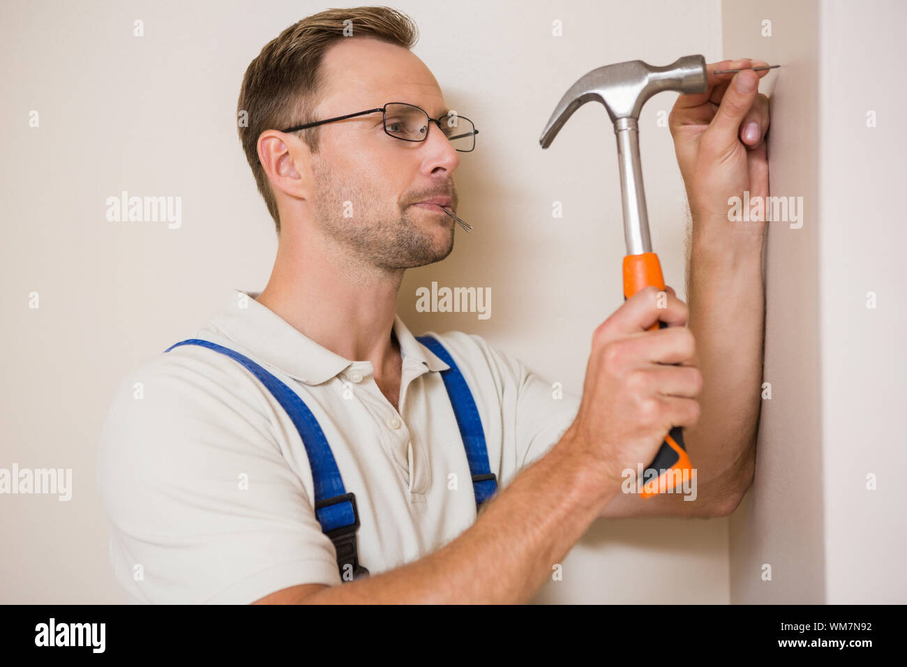 гвоздь в стене. вбить молотком в стену. молоток забивает гвоздь. вбить молотком в стену. забивает гвоздь.