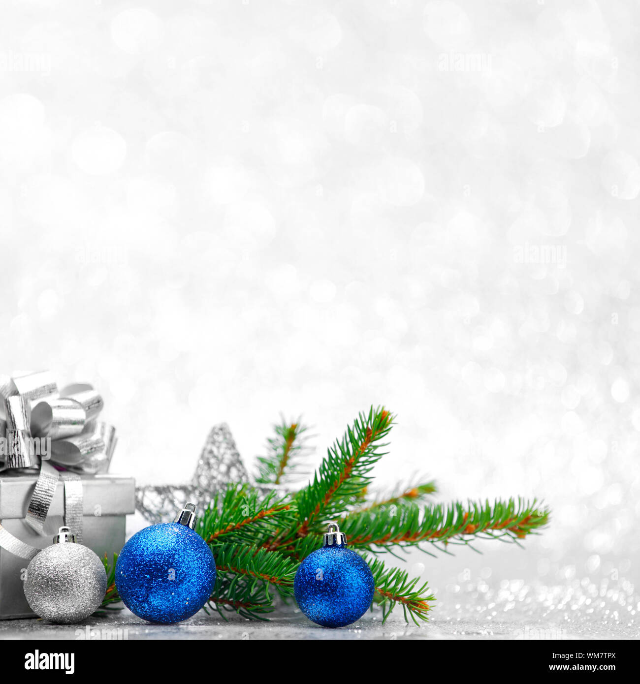 Christmas fir tree branch and decoration on silver glitter background ...