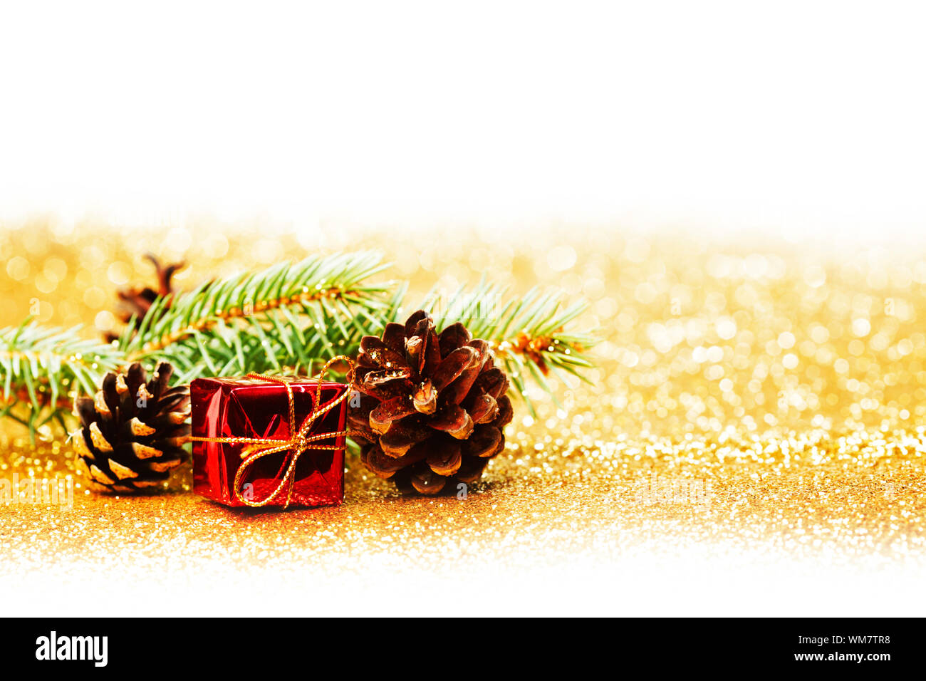 Christmas card with fir tree branch and decoration on golden glitter ...