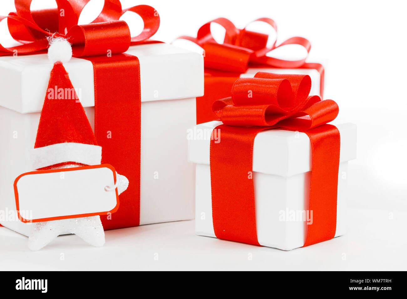 White gift boxes with red ribbons, stars with santa claus hats isolated ...