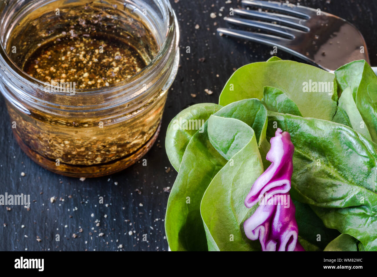 High Angle View Of Vinegar With Leaf Vegetable On Table Stock Photo