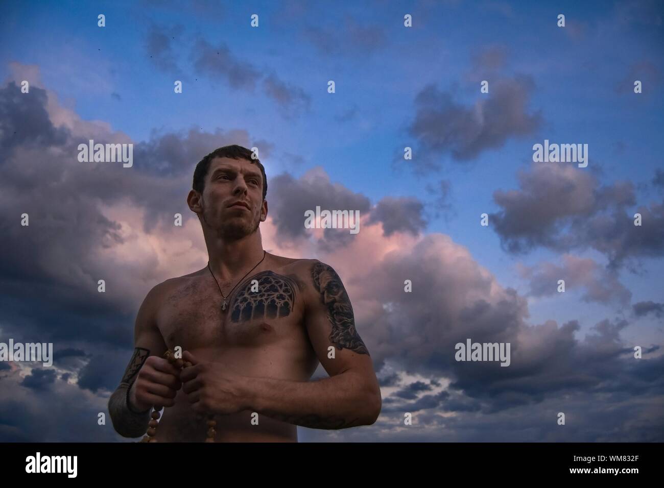 Low Angle View Of Shirtless Man With Tattoo Against Cloudy Sky Stock Photo Alamy Low Angle View Of Shirtless Man With Tattoo Against Cloudy Sky Stock Photo Alamy