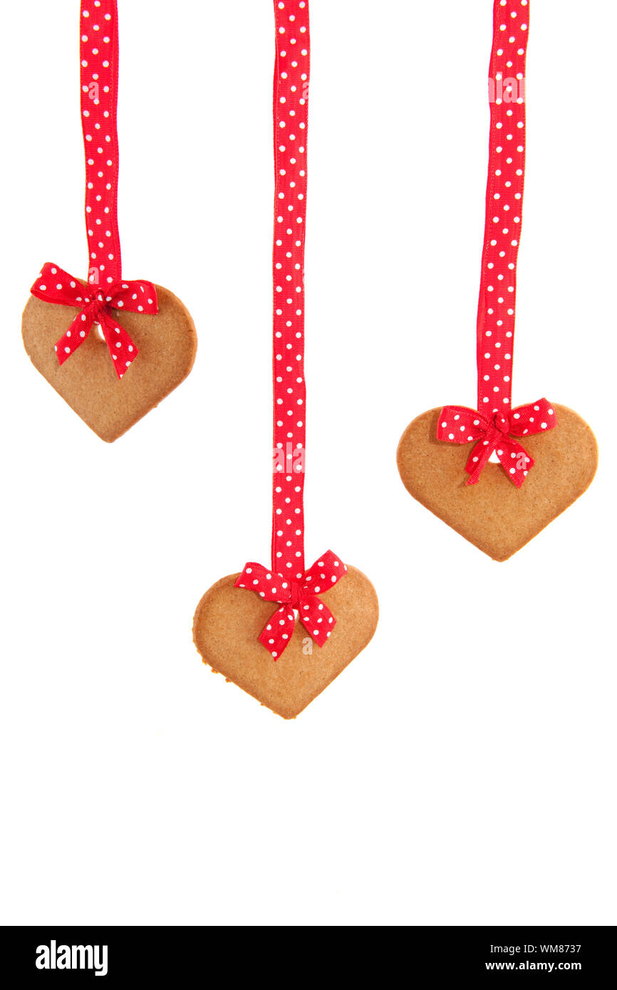 Baked gingerbread hearts with red speckles bows and ribbon Stock Photo