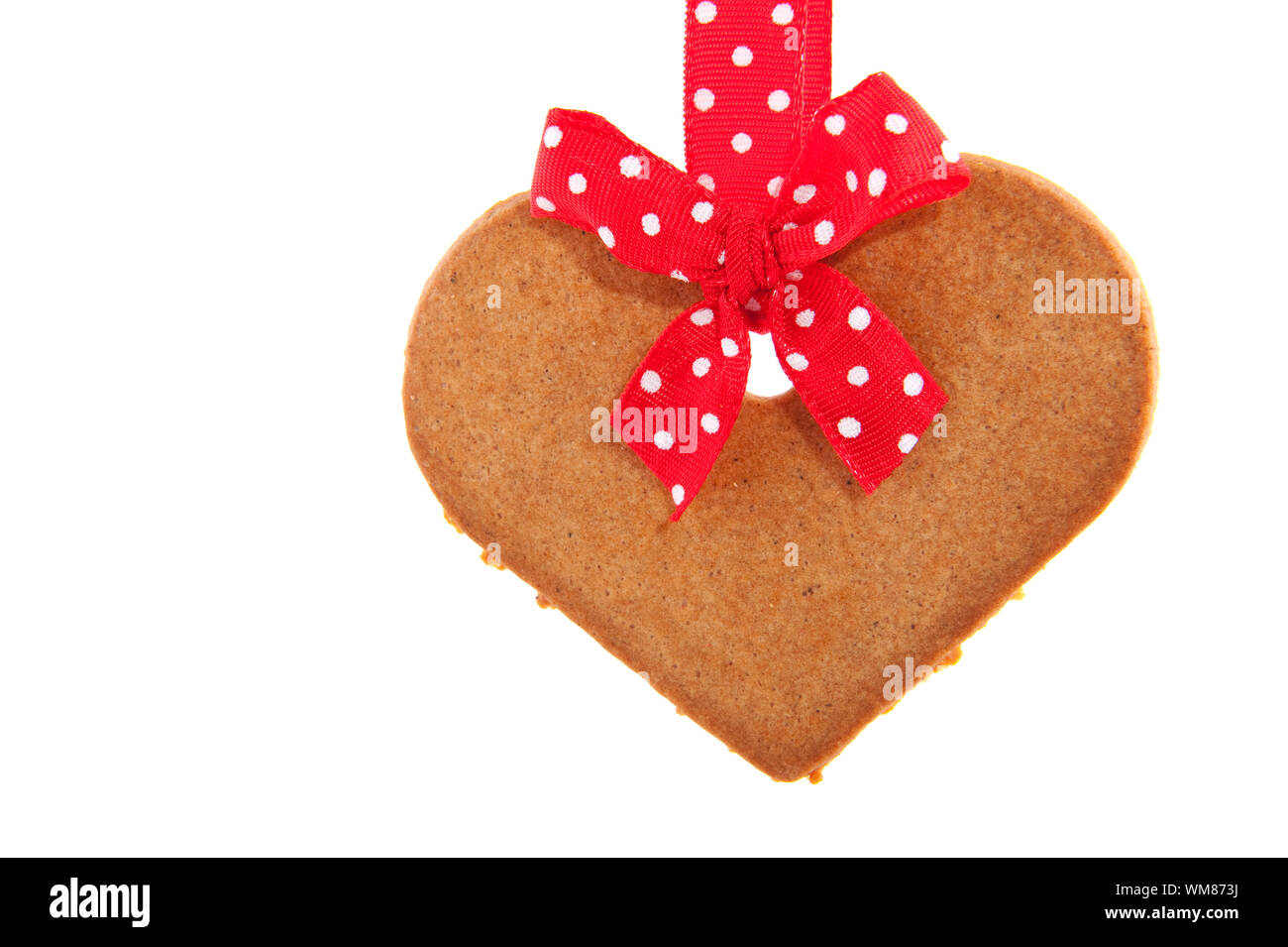 Baked gingerbread heart coookie with red speckles bows and ribbon Stock Photo