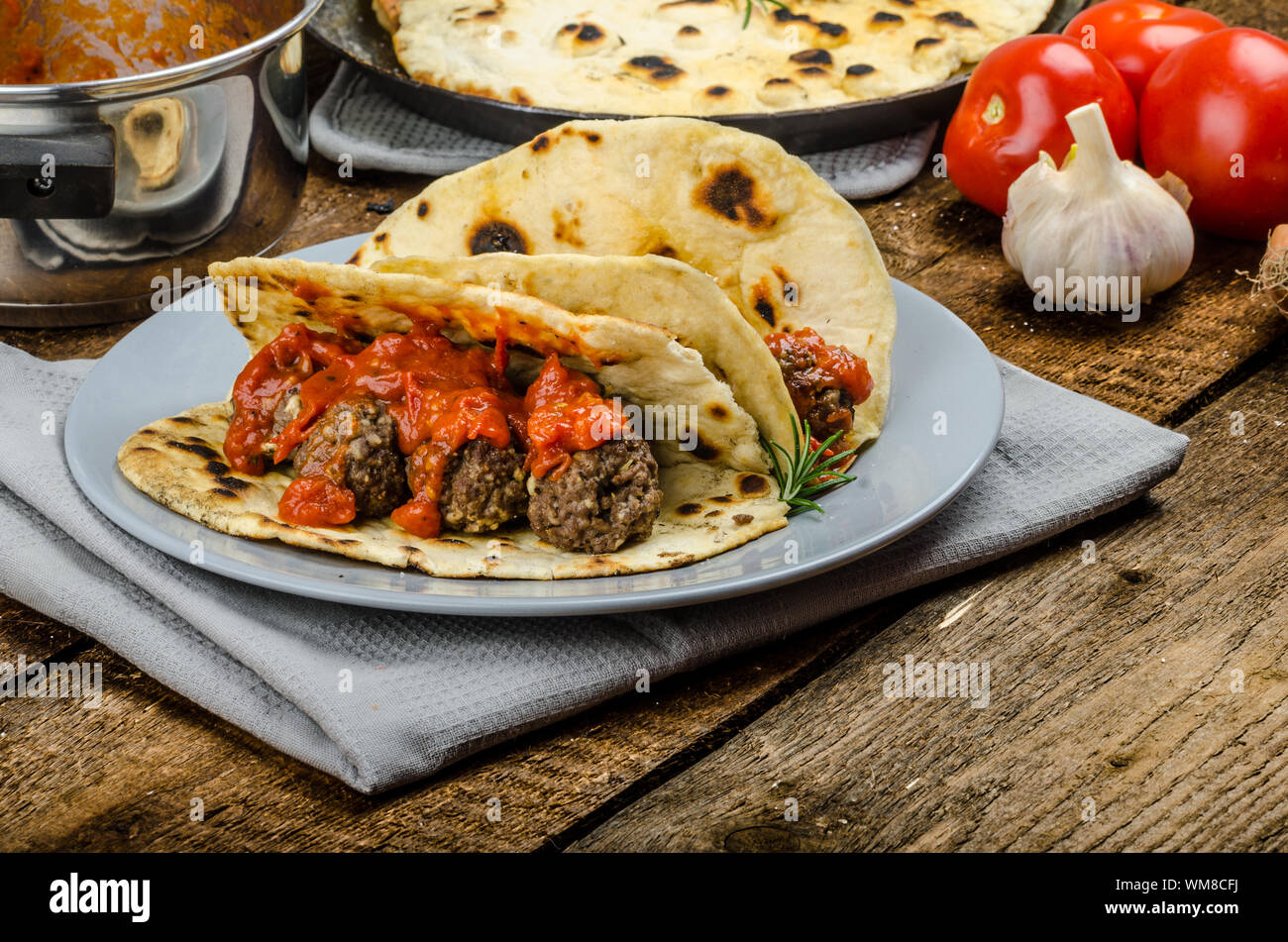 Indian naan with meatballs and tomato sauce, spicy sauce and exotic