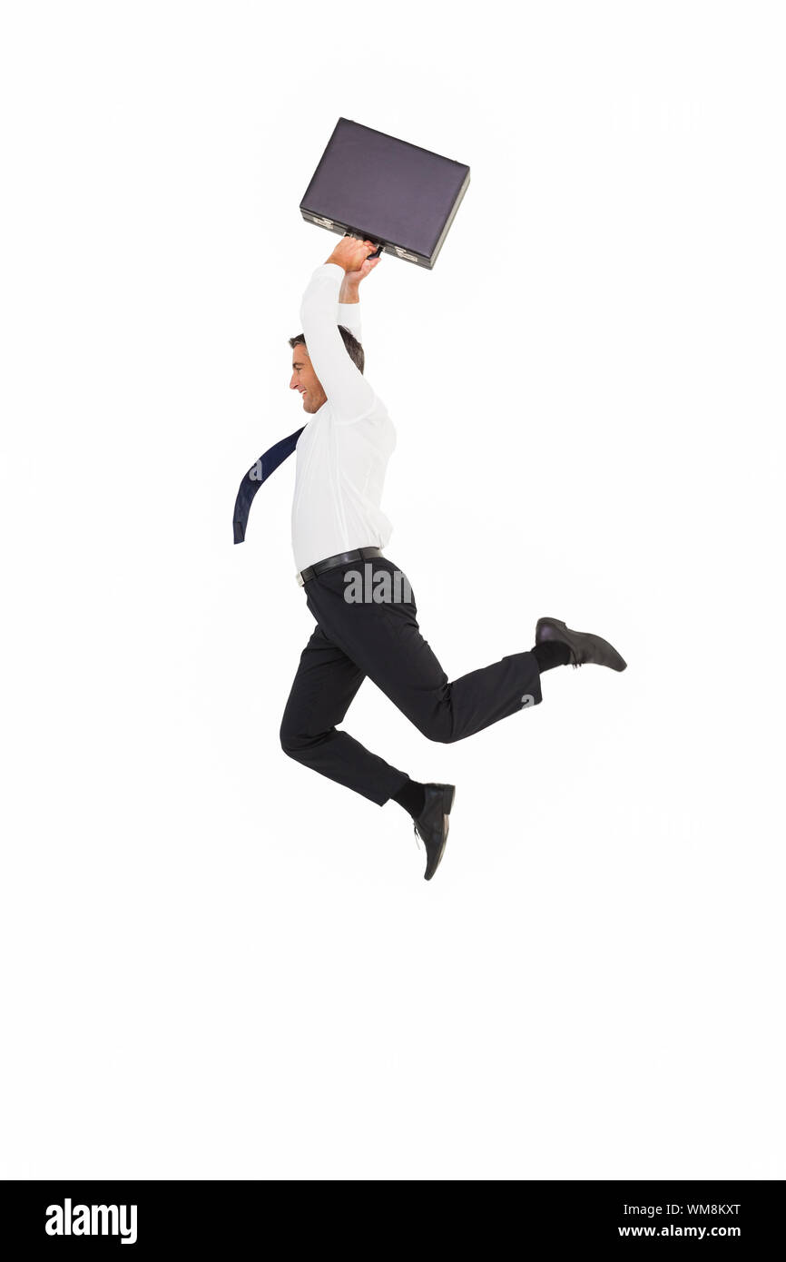 Smiling businessman leaping while briefcase on white background Stock Photo
