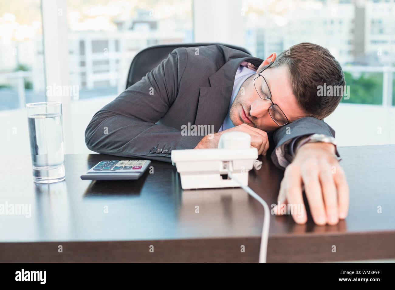 Exhausted businessman sleeping at his desk in his office Stock Photo ...