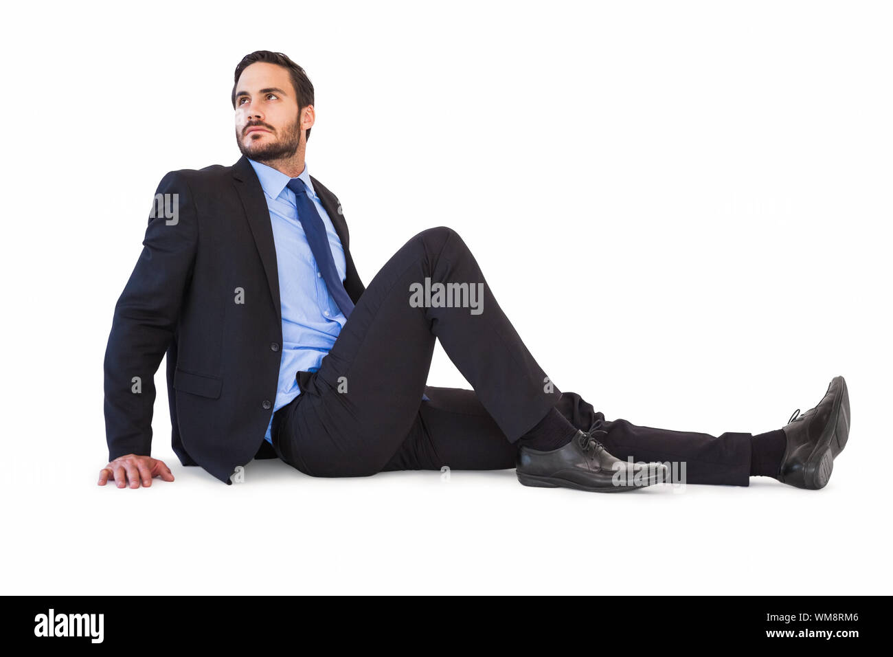 Relaxed businessman sitting on the floor on white background Stock ...