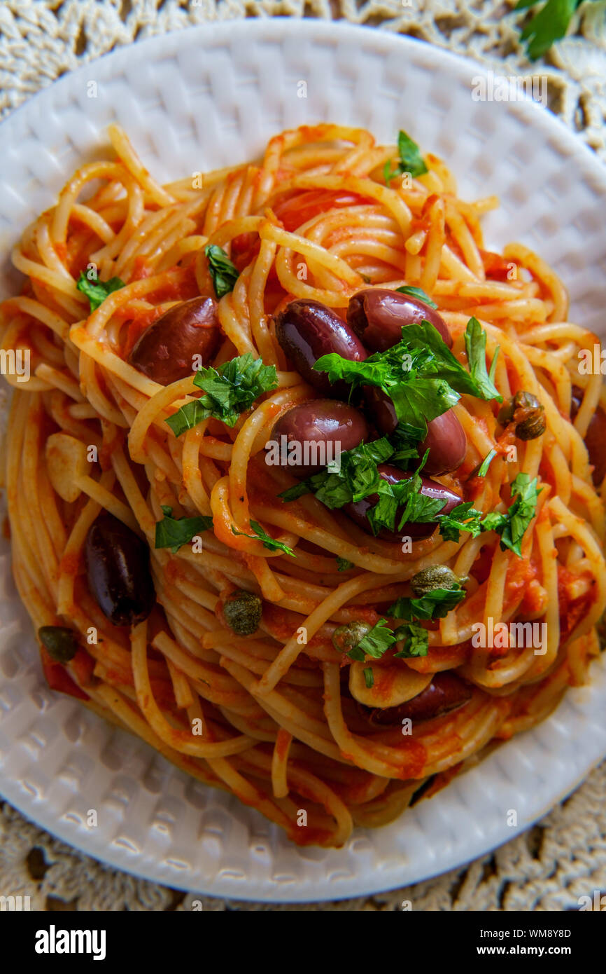 Delicious Italian spaghetti alla puttanesca with kalamata olives and capers Stock Photo