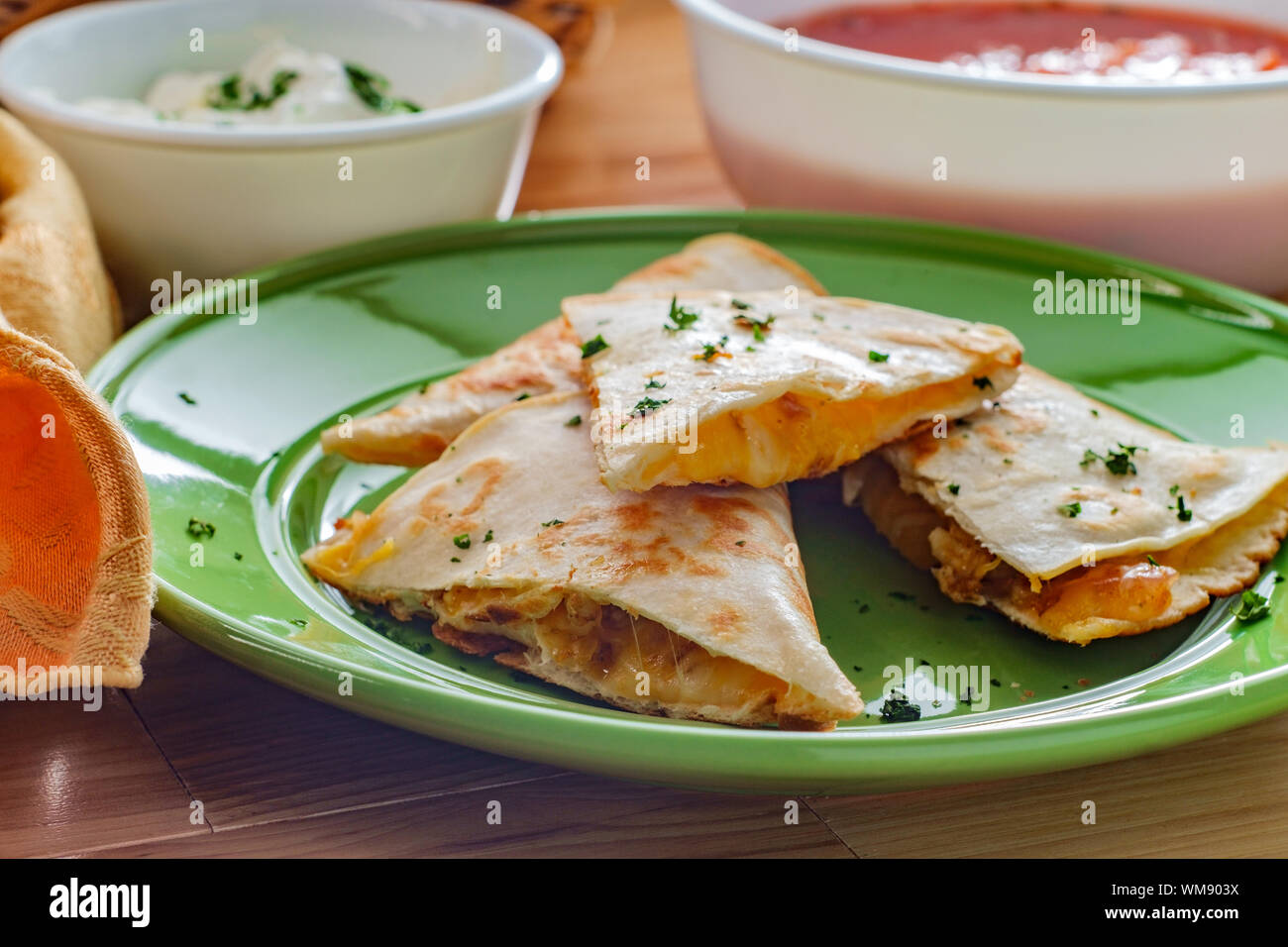 Cheesy chicken quesadilla cut into triangles with tortilla chips salsa