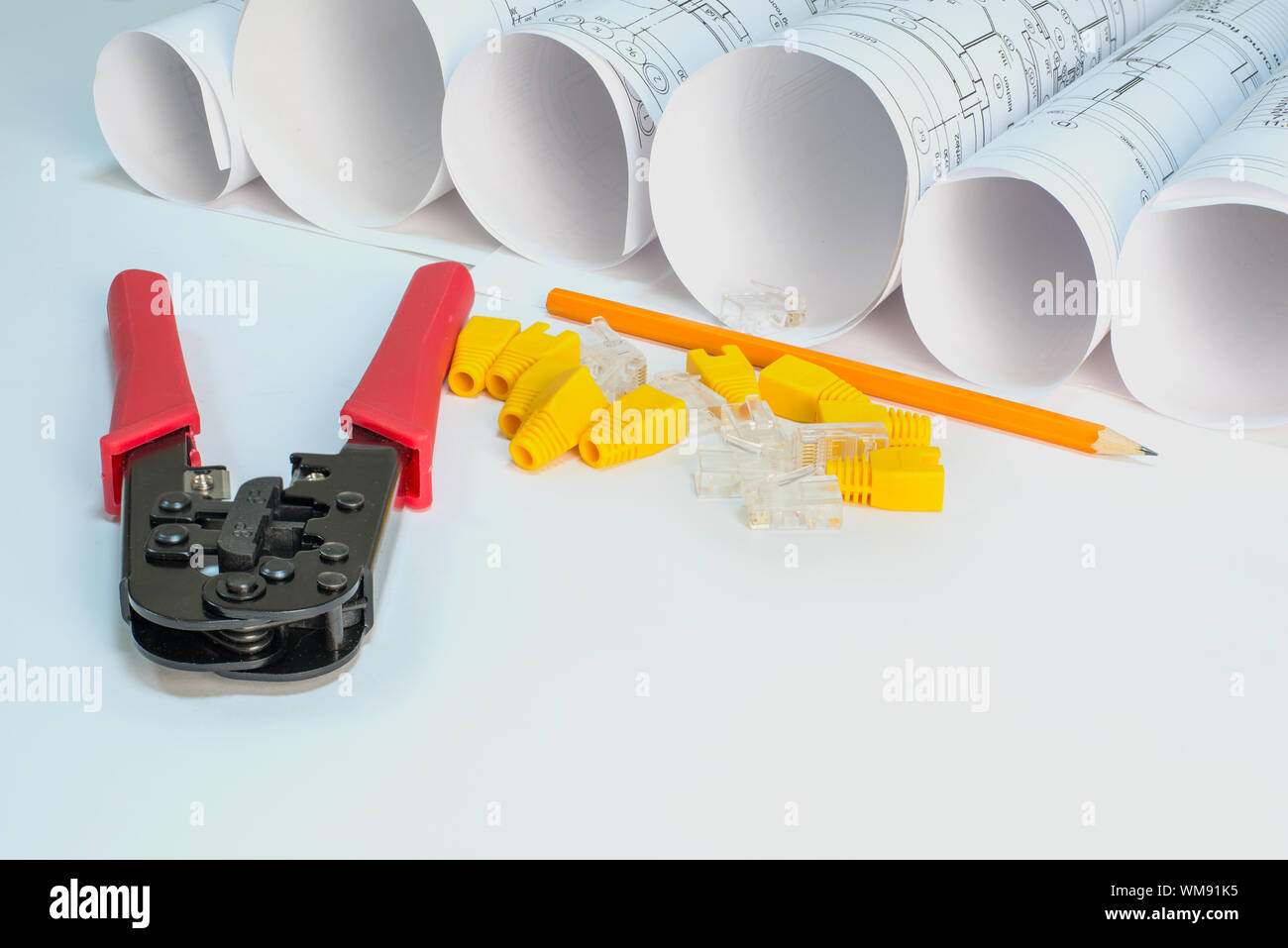 Drawing rolls, crimping pliers, connectors, boot caps, pencil on white