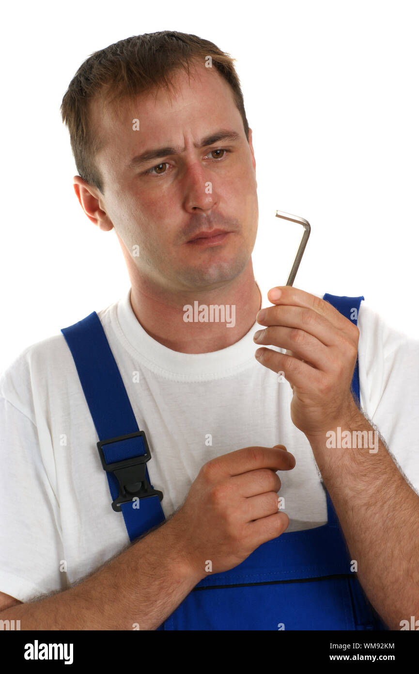 Craftsmen in blue overalls holding an allen key Stock Photo