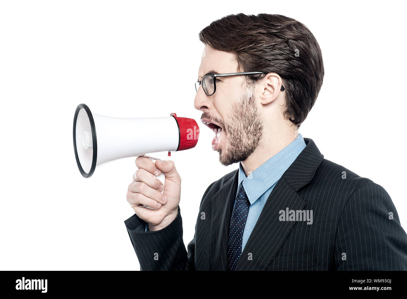 Angry businessman shouting into a megaphone Stock Photo