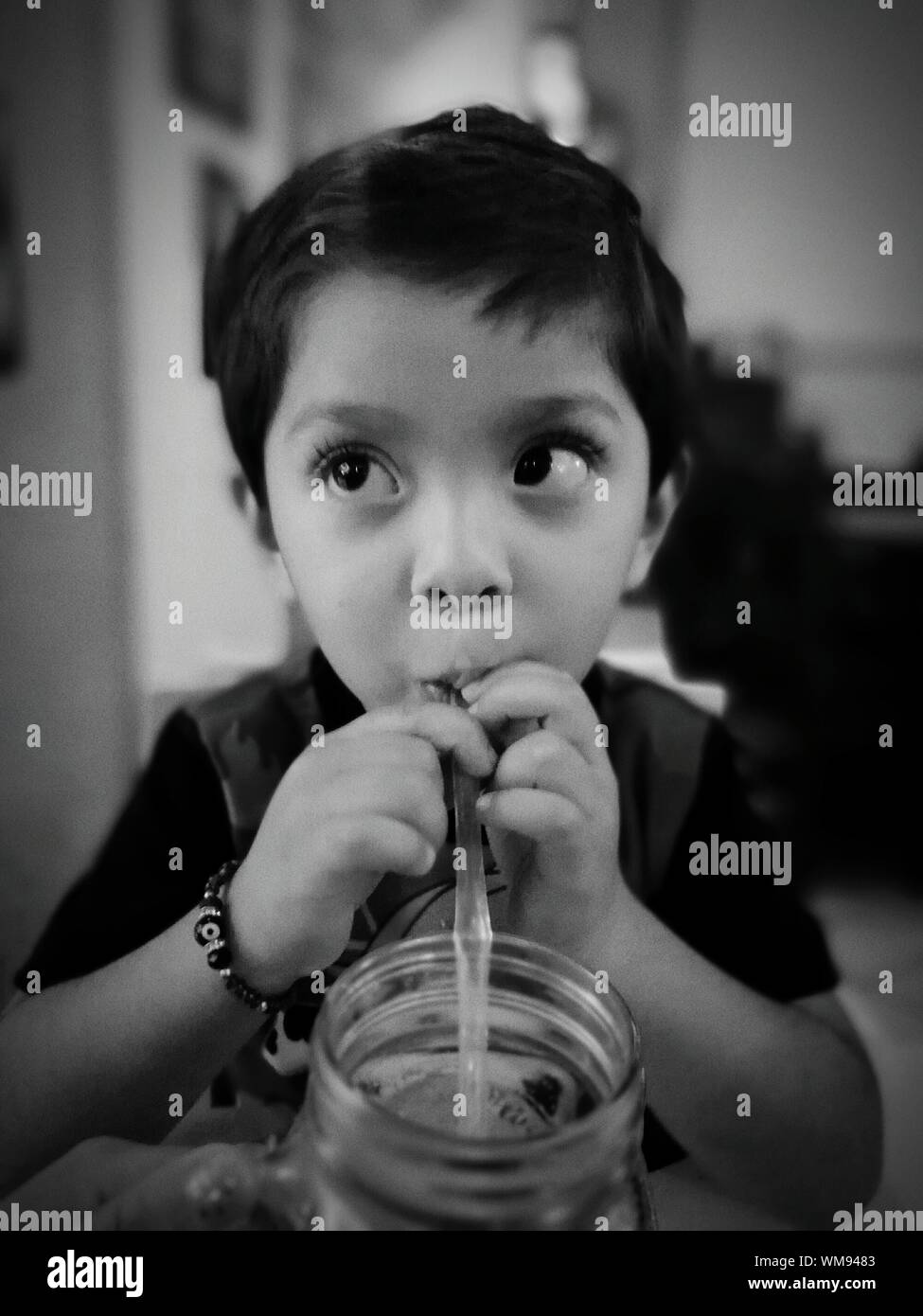 Boy Sipping Drink At Home Stock Photo