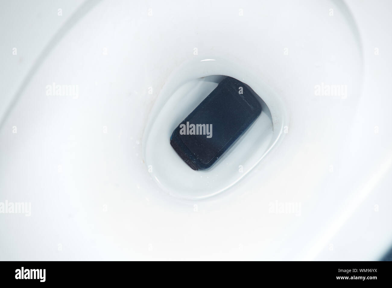 Smartphone dropped to the toilet bowl. Horizontal photo Stock Photo