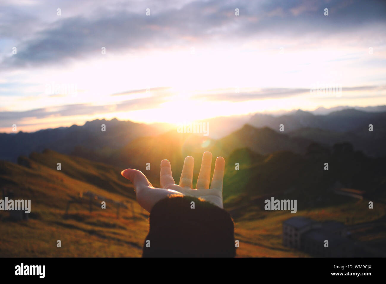 Hand Outstretched Towards Scenic View Of Mountains Stock Photo