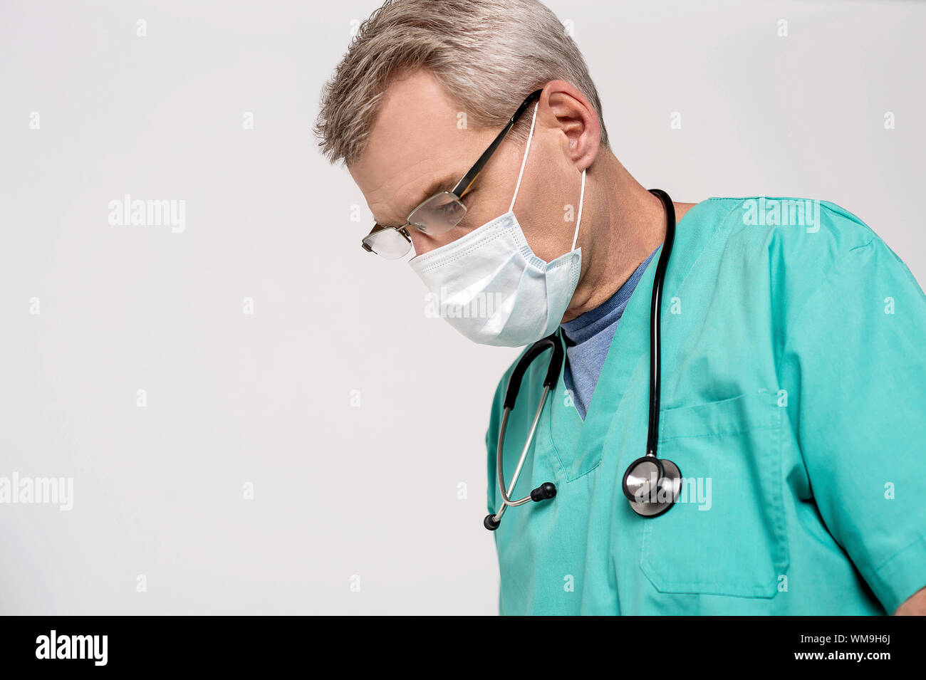 Concentrated male doctor with surgical mask Stock Photo - Alamy