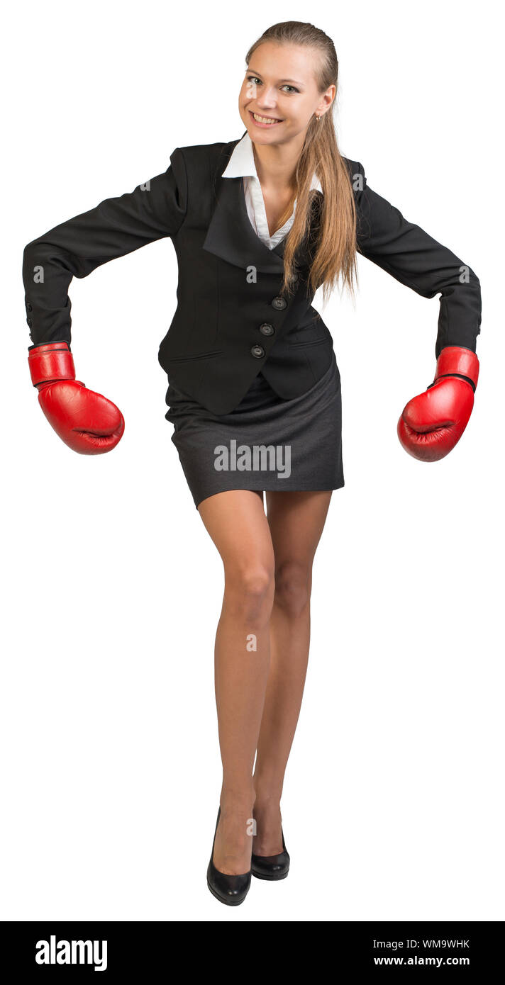 Businesswoman wearing boxing gloves bending forward with her arms forward down, looking at camera, smiling. Isolated over white background Stock Photo