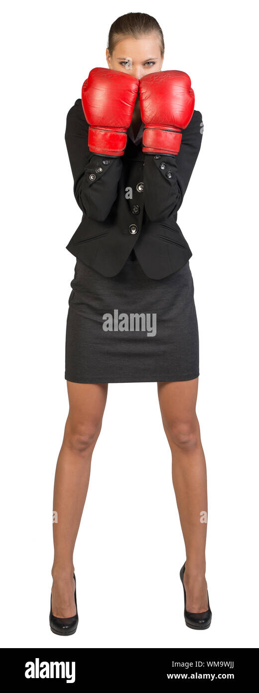 Businesswoman wearing boxing gloves standing in boxing stance, looking