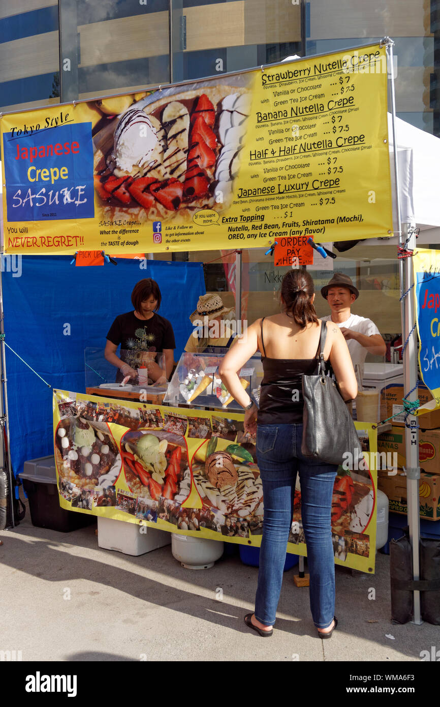 Woman ordering Japanese crepes at a food stall at the2019 Nikkei Matsuri festival, Nikkei Cultural Centre,  Burnaby, Vancouver, BC, Canada Stock Photo