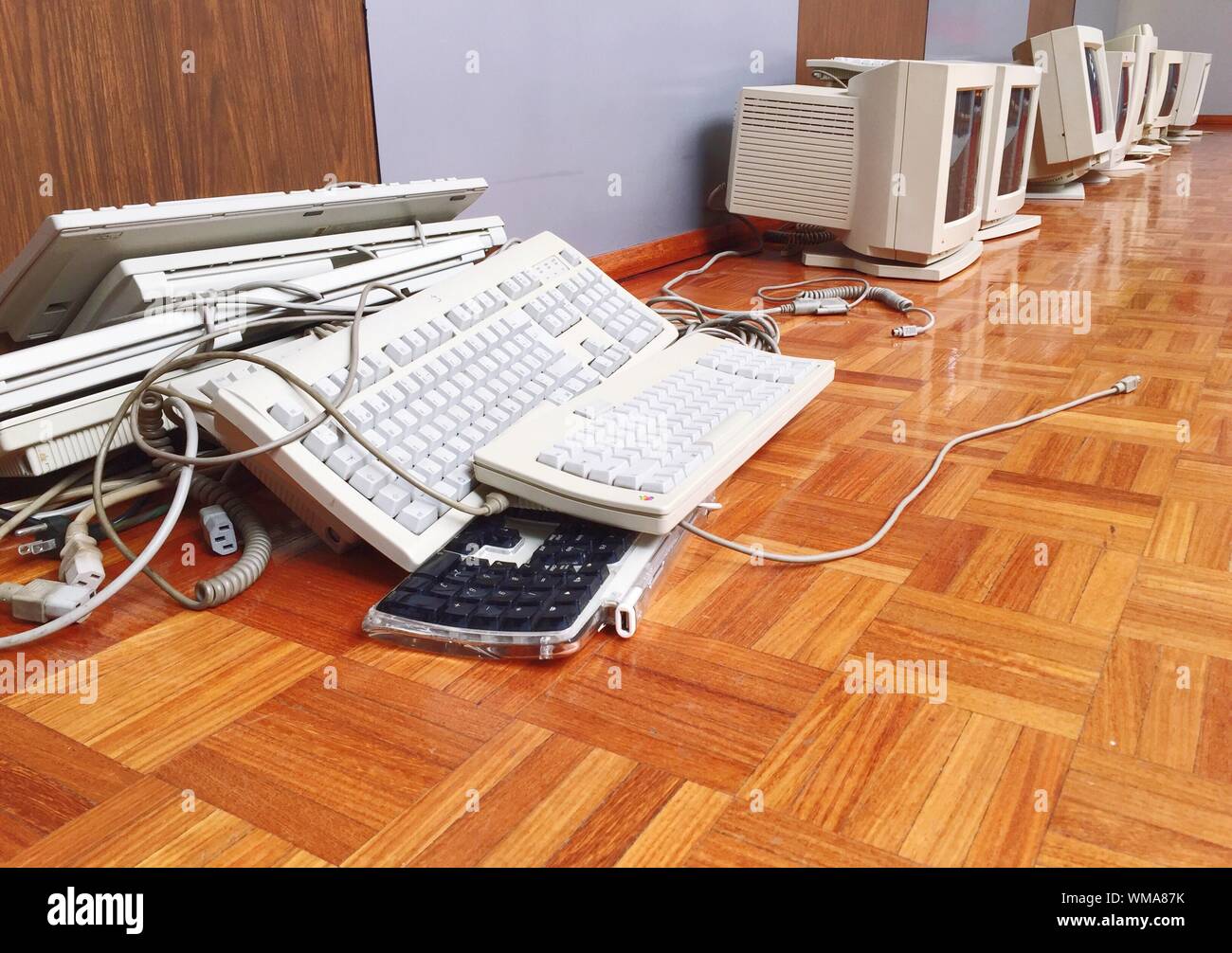 Computer Monitors And Keyboards On Hardwood Floor Stock Photo