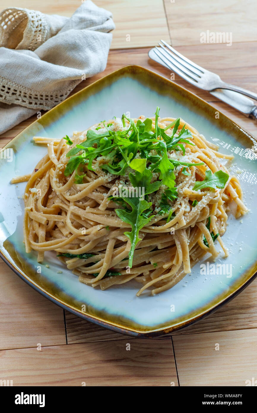 Whole wheat Italian fettuccine alfredo with arugula garnish Stock Photo