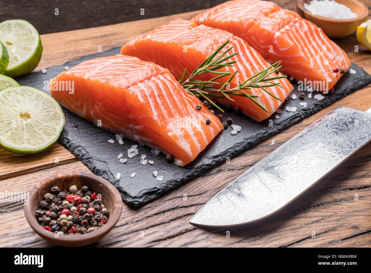 Fresh salmon fillets on black cutting board with herbs and spices Stock ...