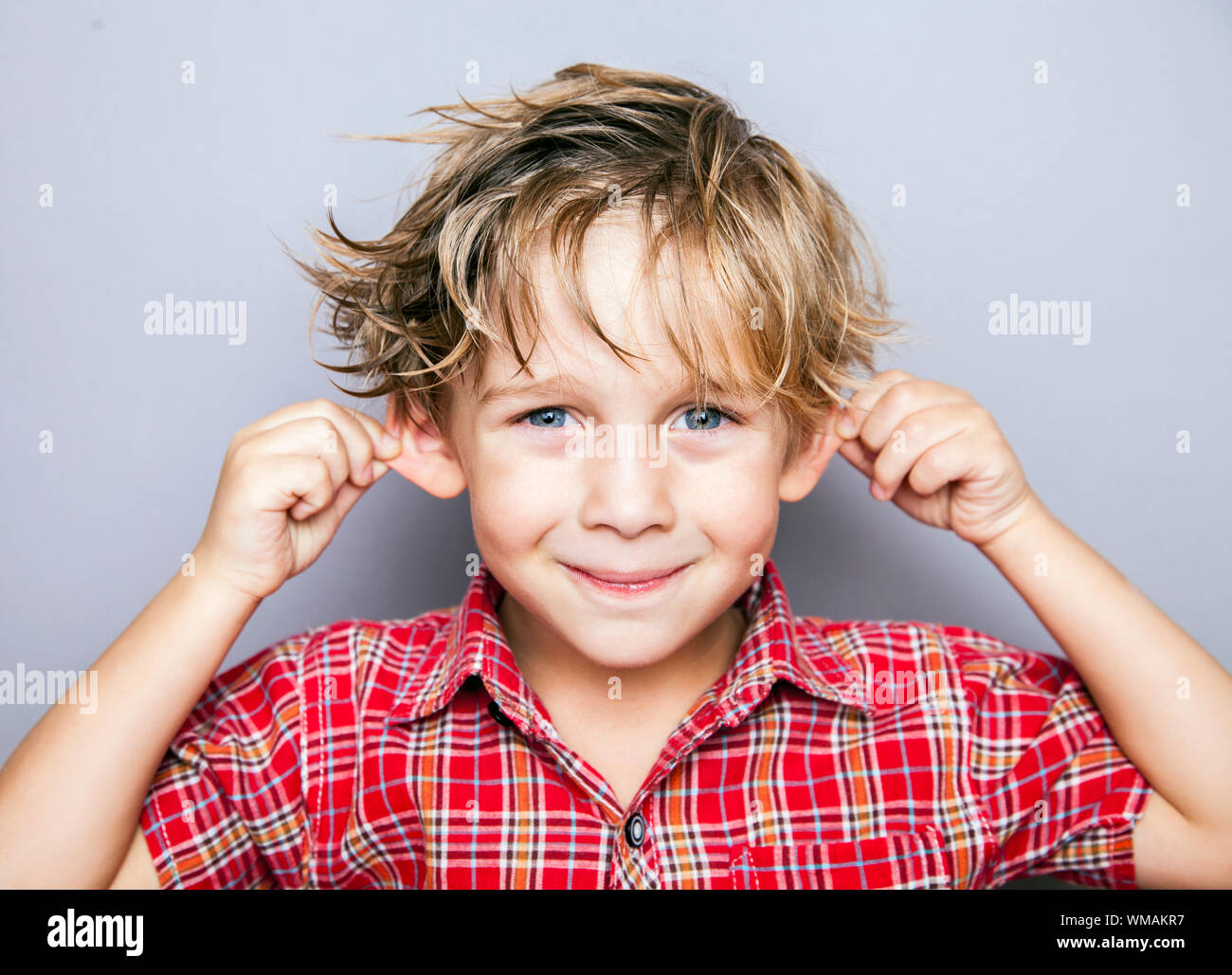 Handsome smiling boy in front of a grey background Stock Photo