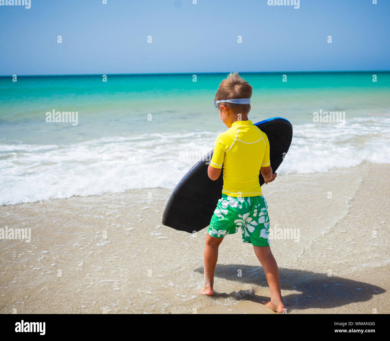 Little boy in yellow has fun surfing Stock Photo - Alamy