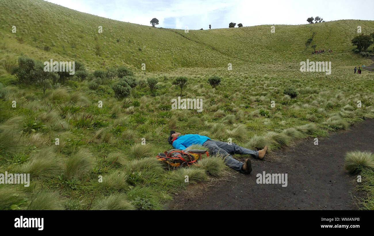Hiker Laying Down On Field Stock Photo