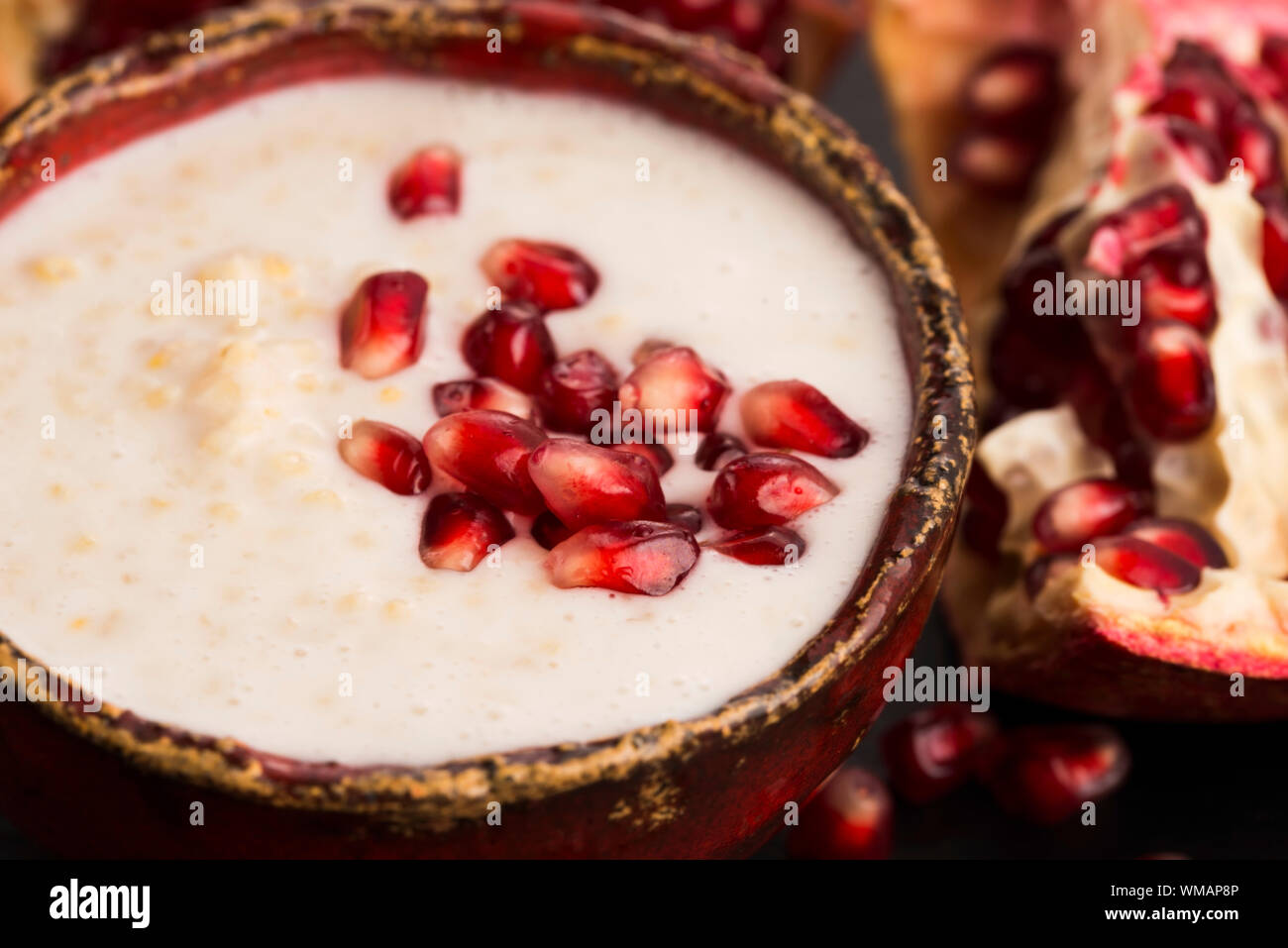 Dish of banana millet breakfast pudding with pomegranate Stock Photo