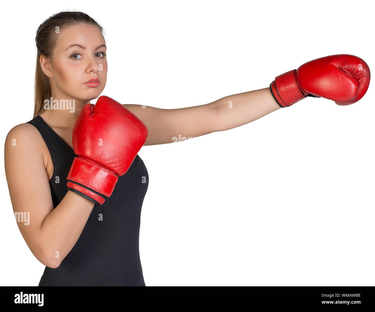 Woman wearing boxing gloves, in punching pose, looking at camera. Isolated on white background Stock Photo
