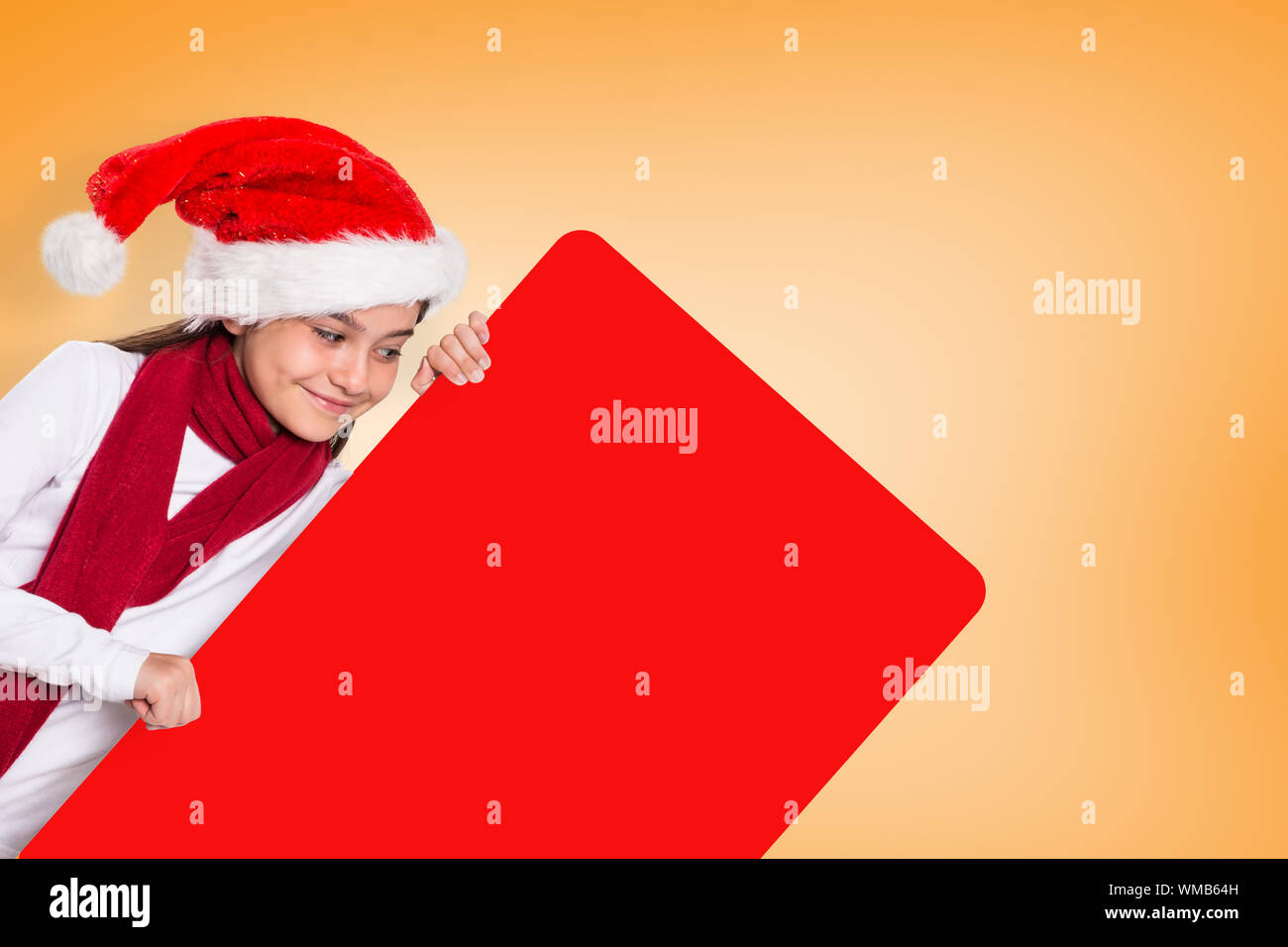 Festive little girl showing card against orange background Stock Photo - Alamy