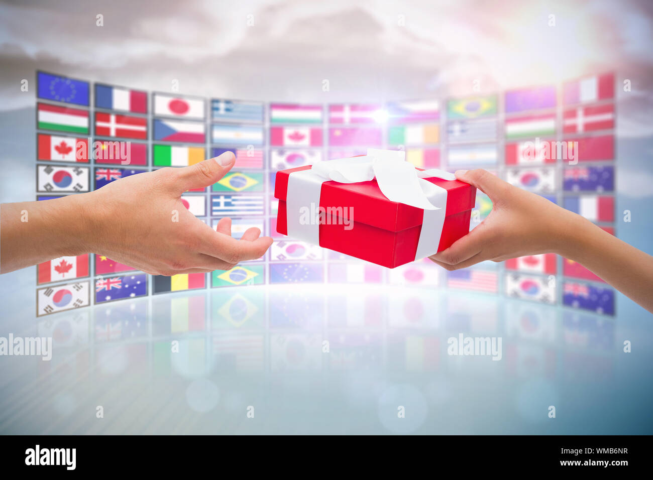 Couple passing a wrapped gift against screen collage showing ...