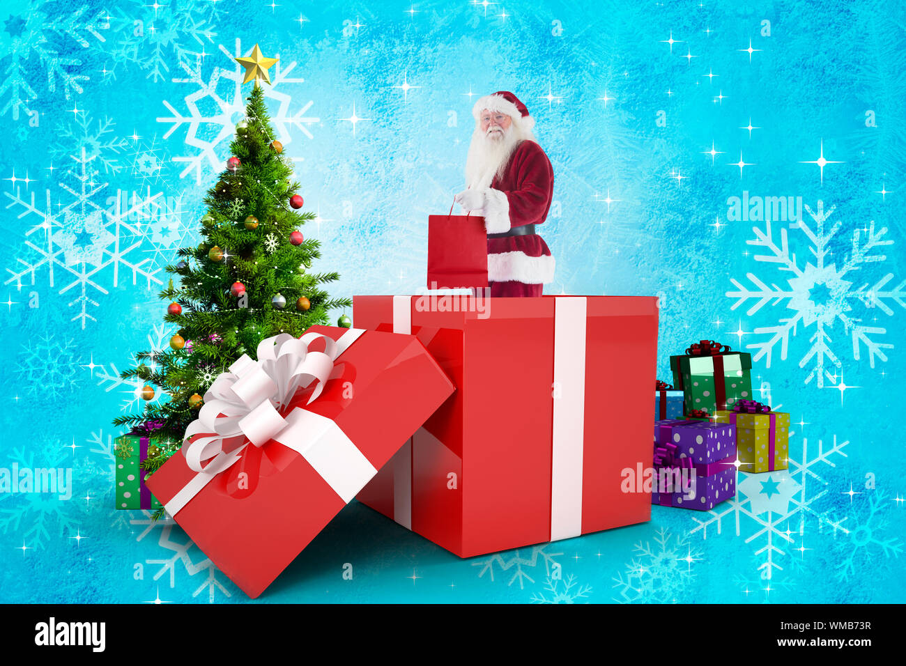 Santa standing in large gift against christmas tree with gifts Stock ...