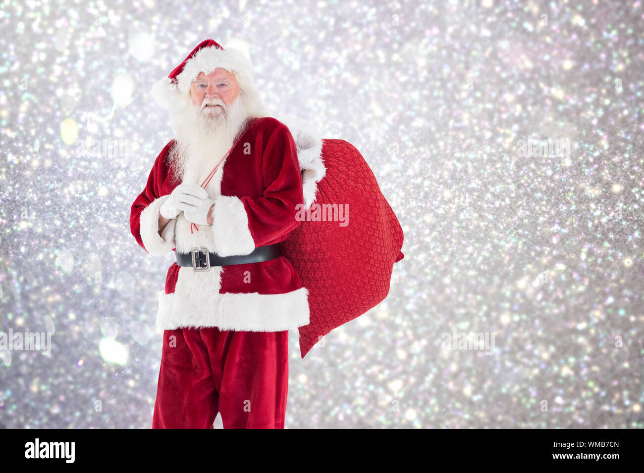 Santa carries his red bag against white snow and stars on silver Stock ...