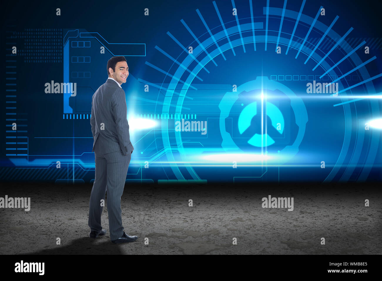 Smiling businessman standing against blue glowing interface Stock Photo