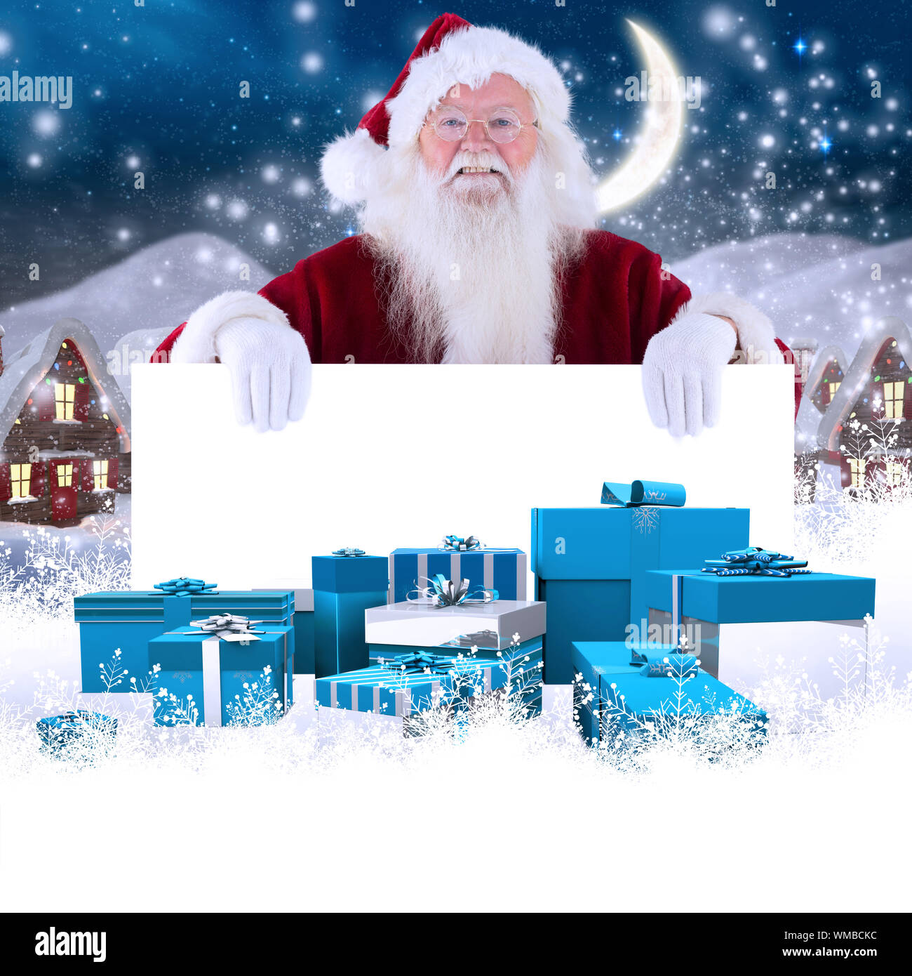 Santa looks over a sign against cute christmas village at night Stock ...