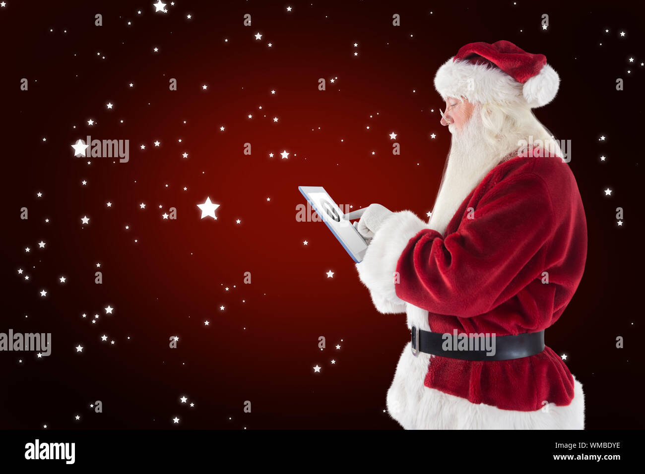 Santa uses a tablet PC against red background with vignette Stock Photo ...