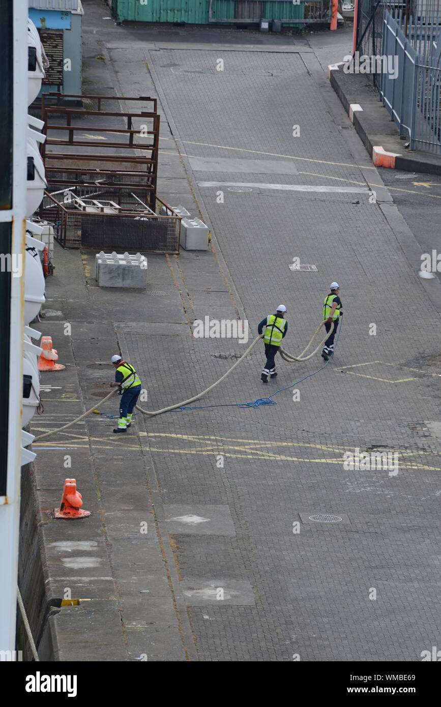 Dock workers haul in a mooring rope from a Holyhead to Dublin Ferry