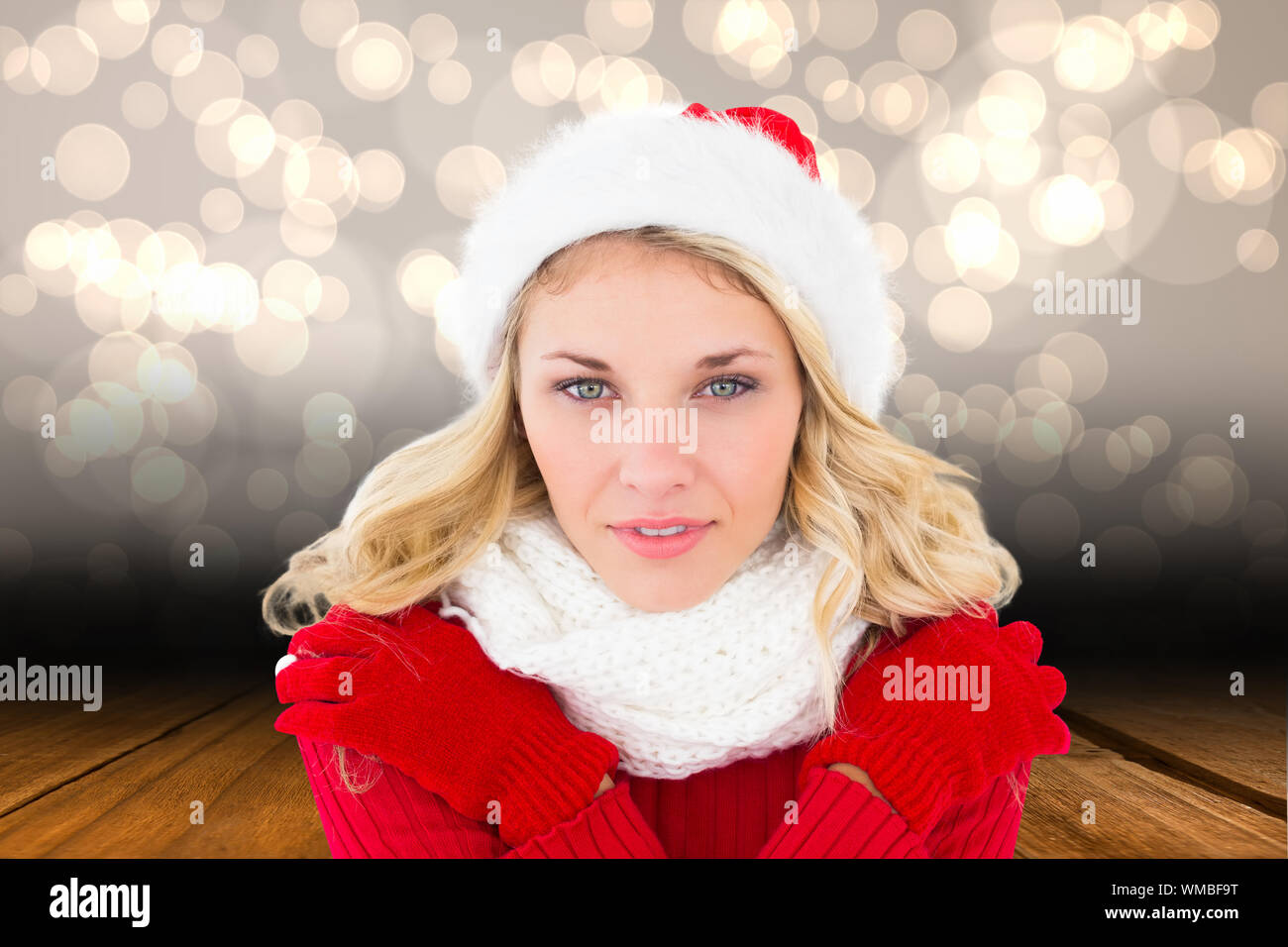 Happy festive blonde  against shimmering light design over boards Stock Photo