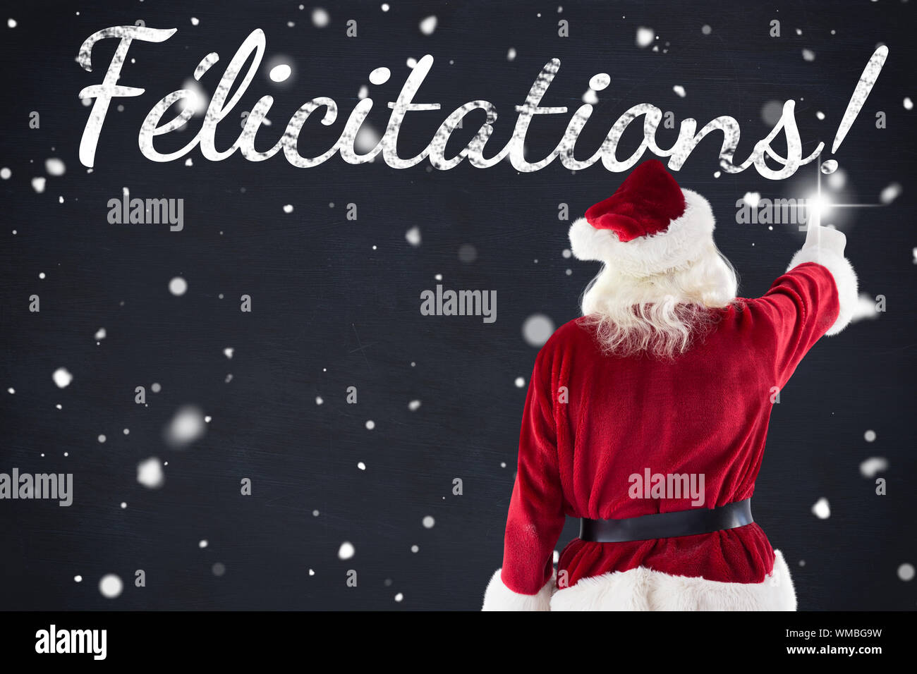 Santa claus points at something against blackboard Stock Photo