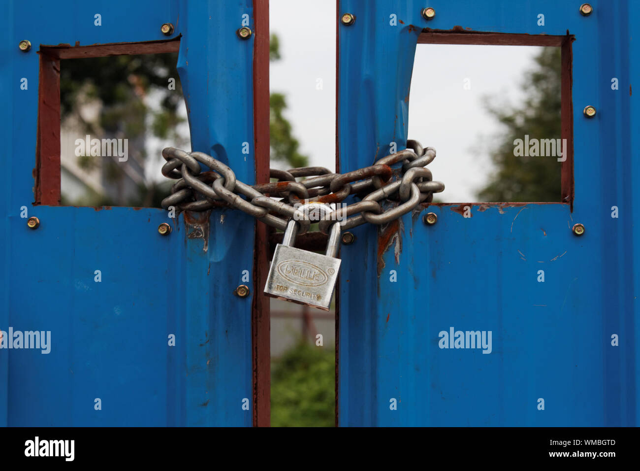 Close-up Of Locked Blue Metal Gate Stock Photo